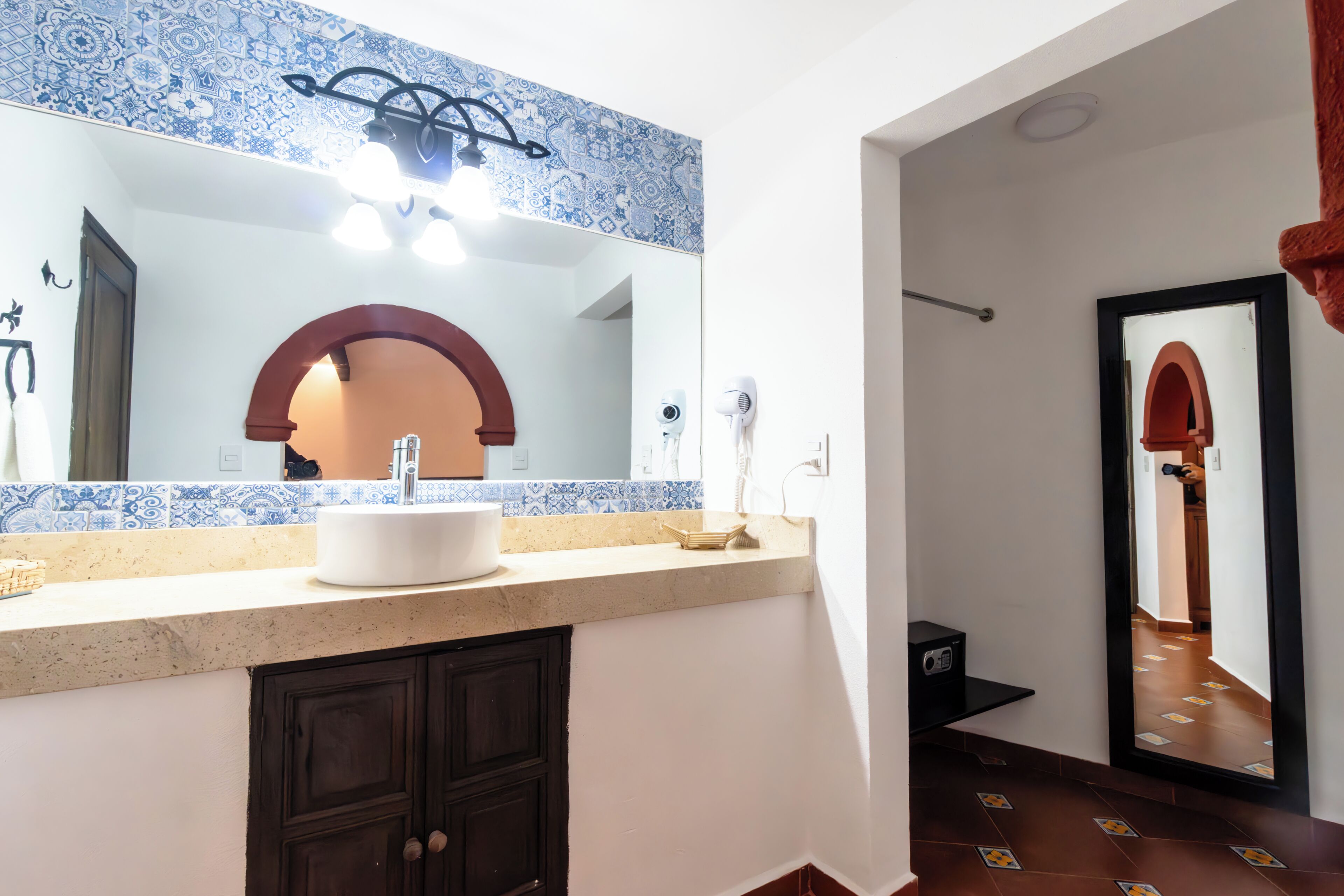A bathroom with a sink, mirror, and towel rack.