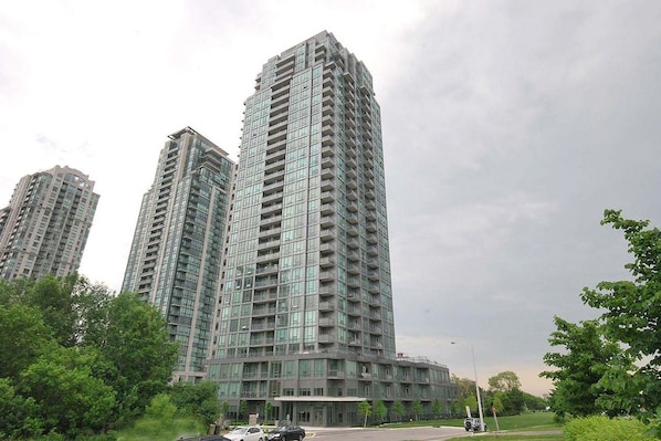 A high-rise residential building with multiple balconies, large windows, and a modern architectural design.