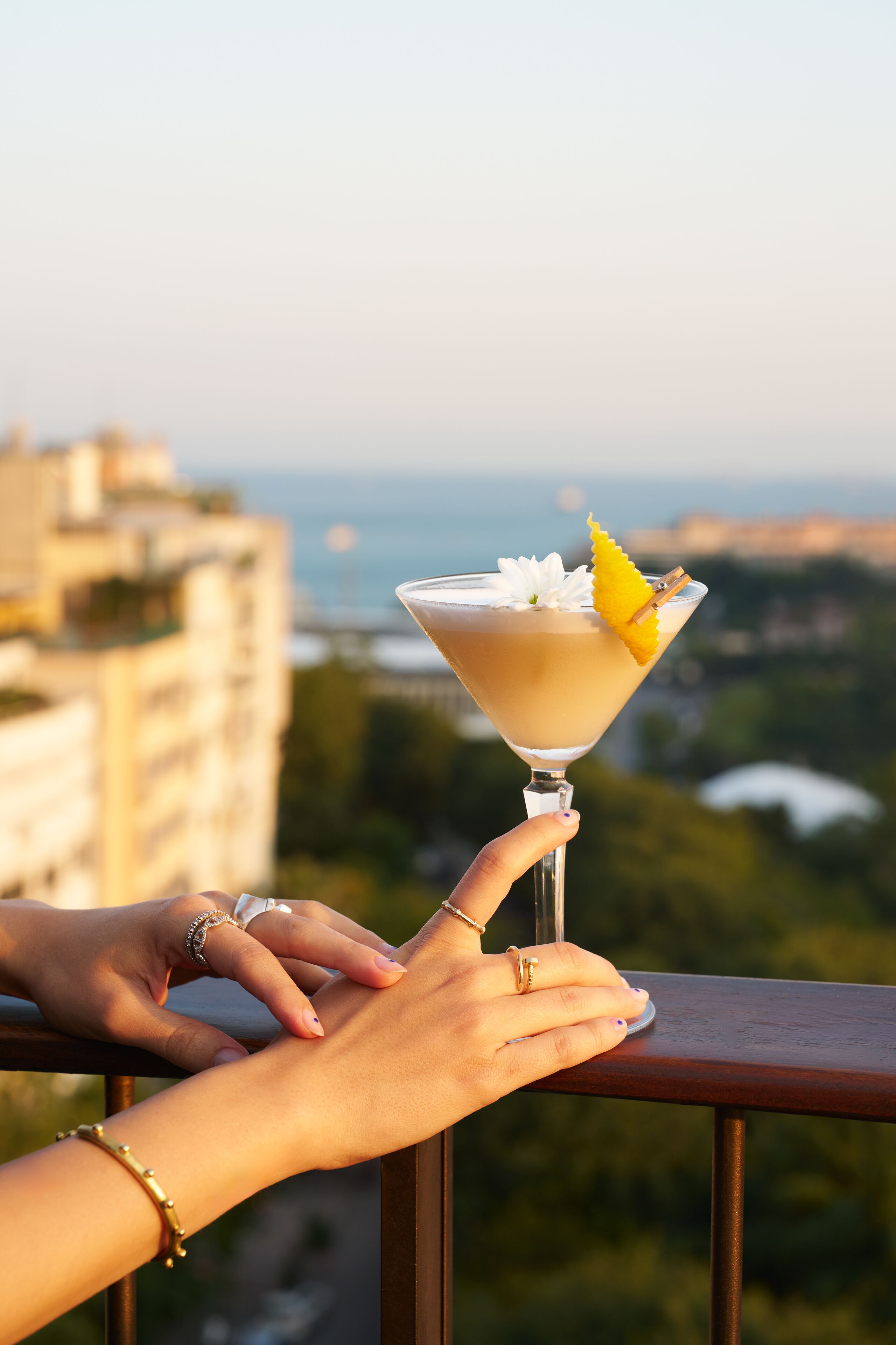 A cocktail on a balcony with a cityscape view.