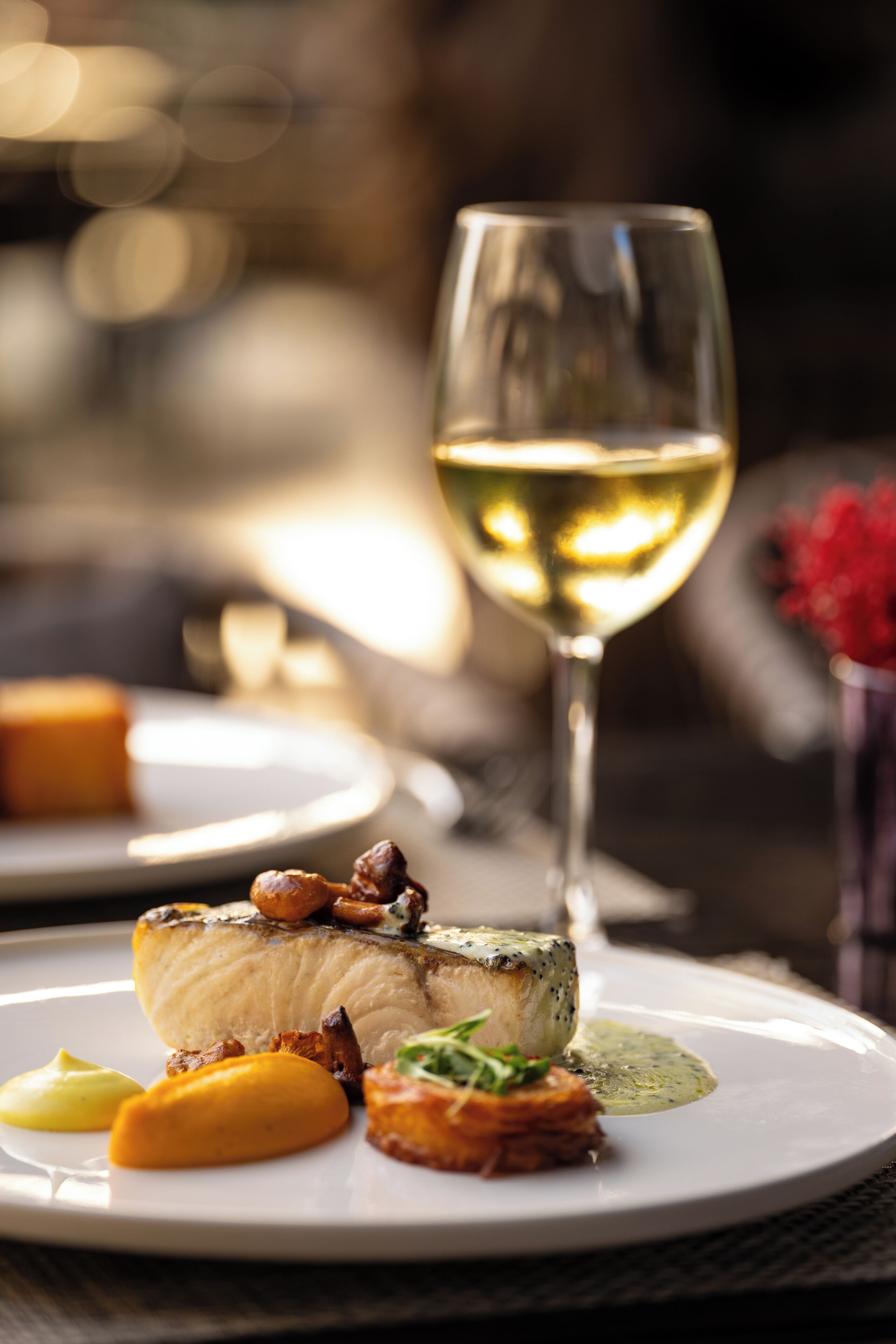 A plate of food with a glass of white wine.