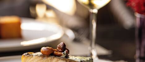 A plate of food with a glass of white wine.