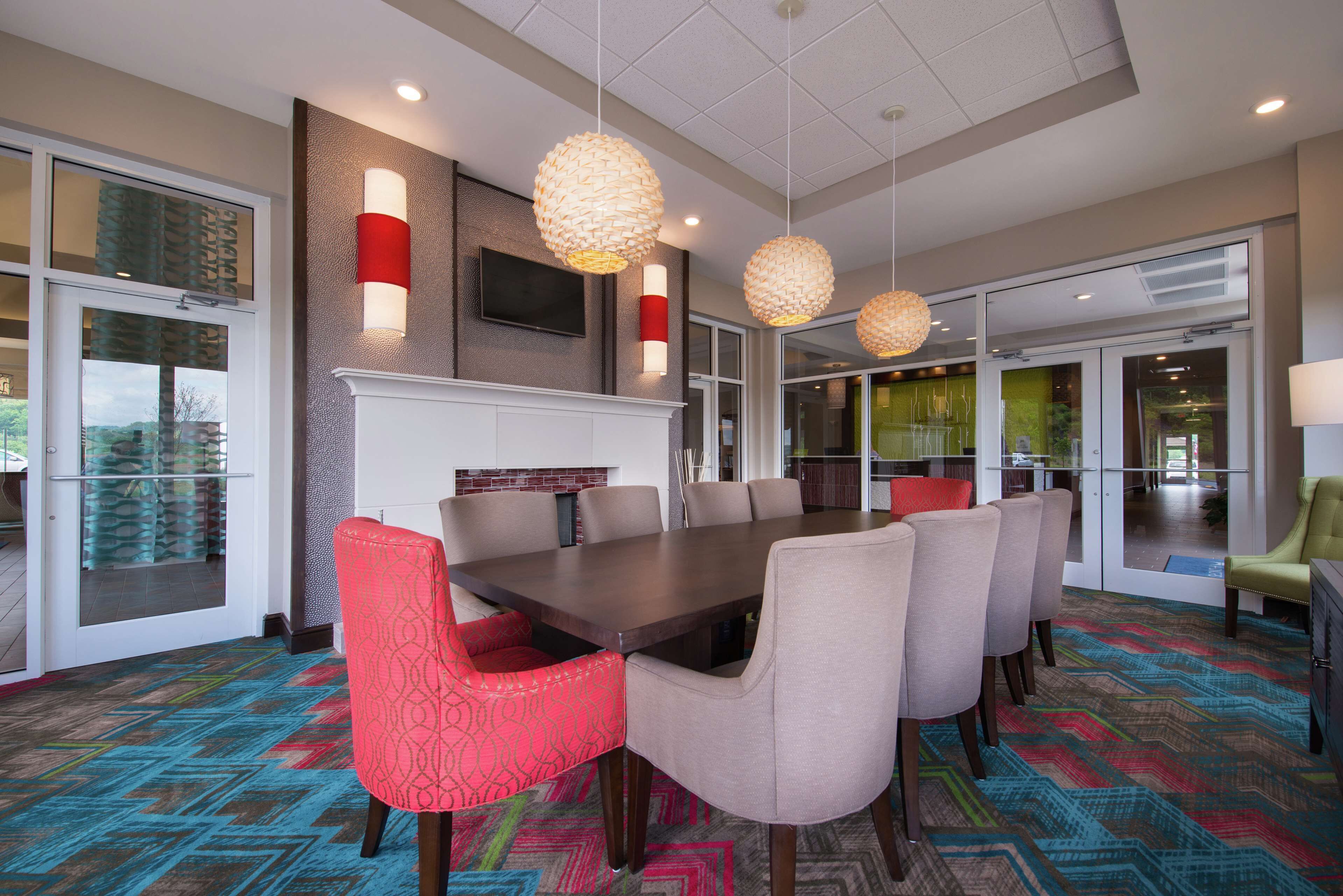 A conference room with a large table, multiple chairs, and pendant lighting.