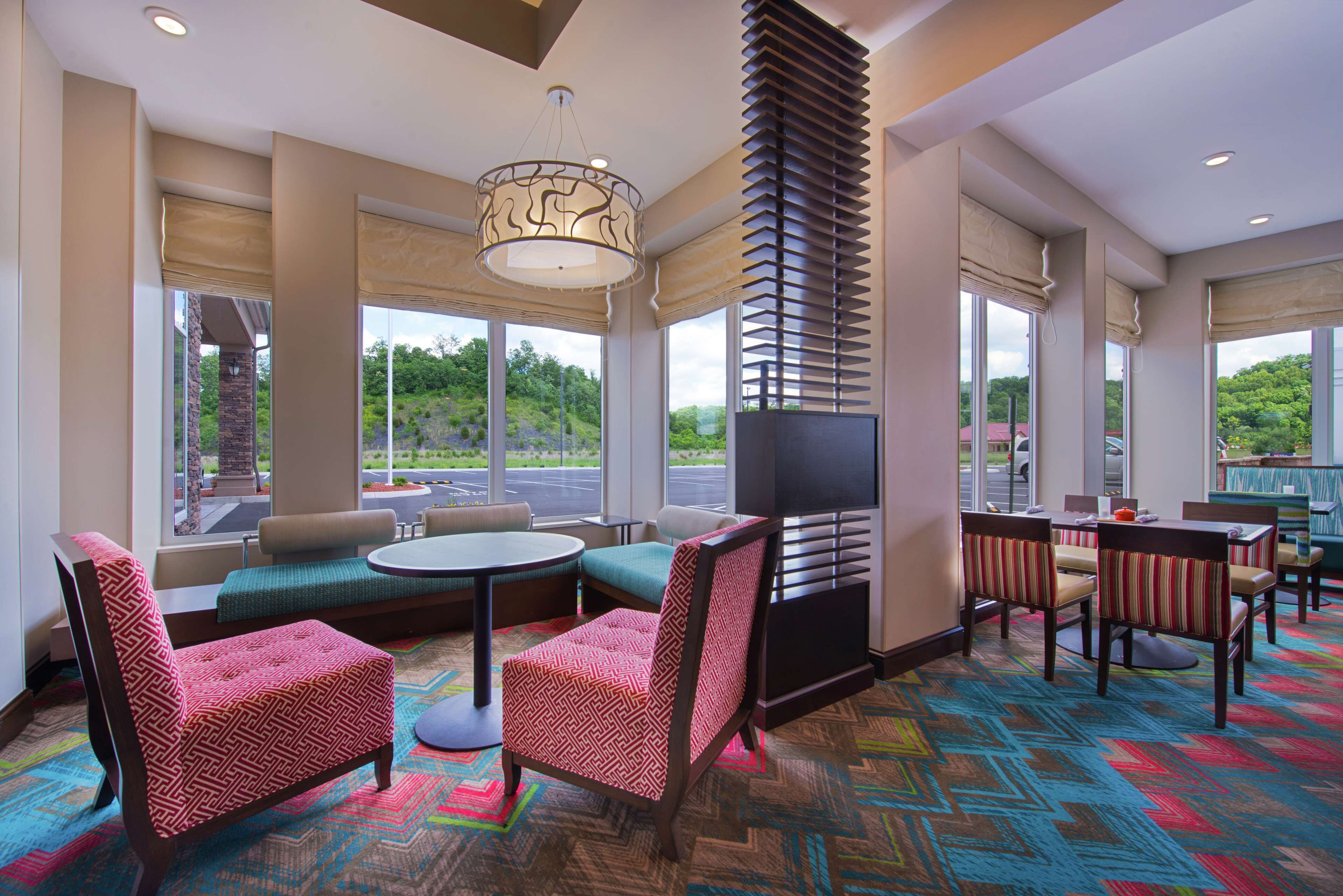 Un hall de hotel con zona de estar, ventanas amplias y vistas al exterior.