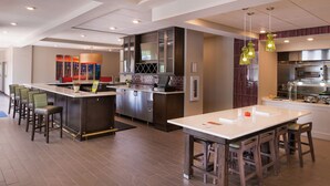 A modern kitchen with a central island, bar stools, and pendant lighting. - Hilton Garden Inn Bristol (Bristol)