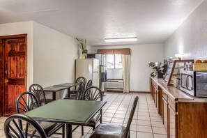 A compact kitchen with a dining area, featuring a refrigerator, microwave, and a small coffee machine. - Rodeway Inn Santa Rosa (Santa Rosa)