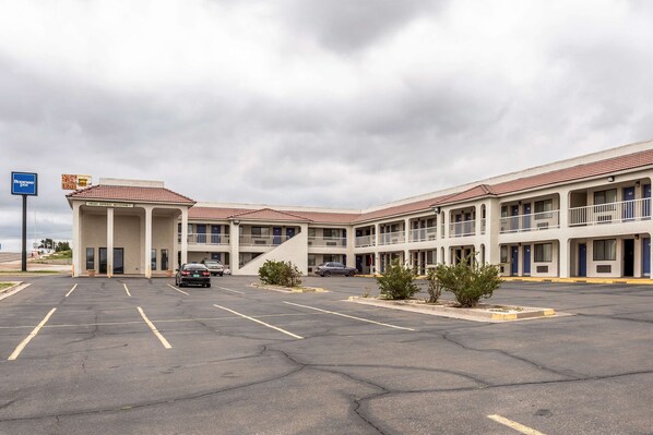 A motel with multiple rooms, a parking lot, and a sign for a fast food restaurant. - Rodeway Inn Santa Rosa (Santa Rosa)