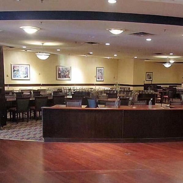 A lobby with a reception desk, seating area, and artwork on the walls. - Speco Hotels Richmond (Richmond)