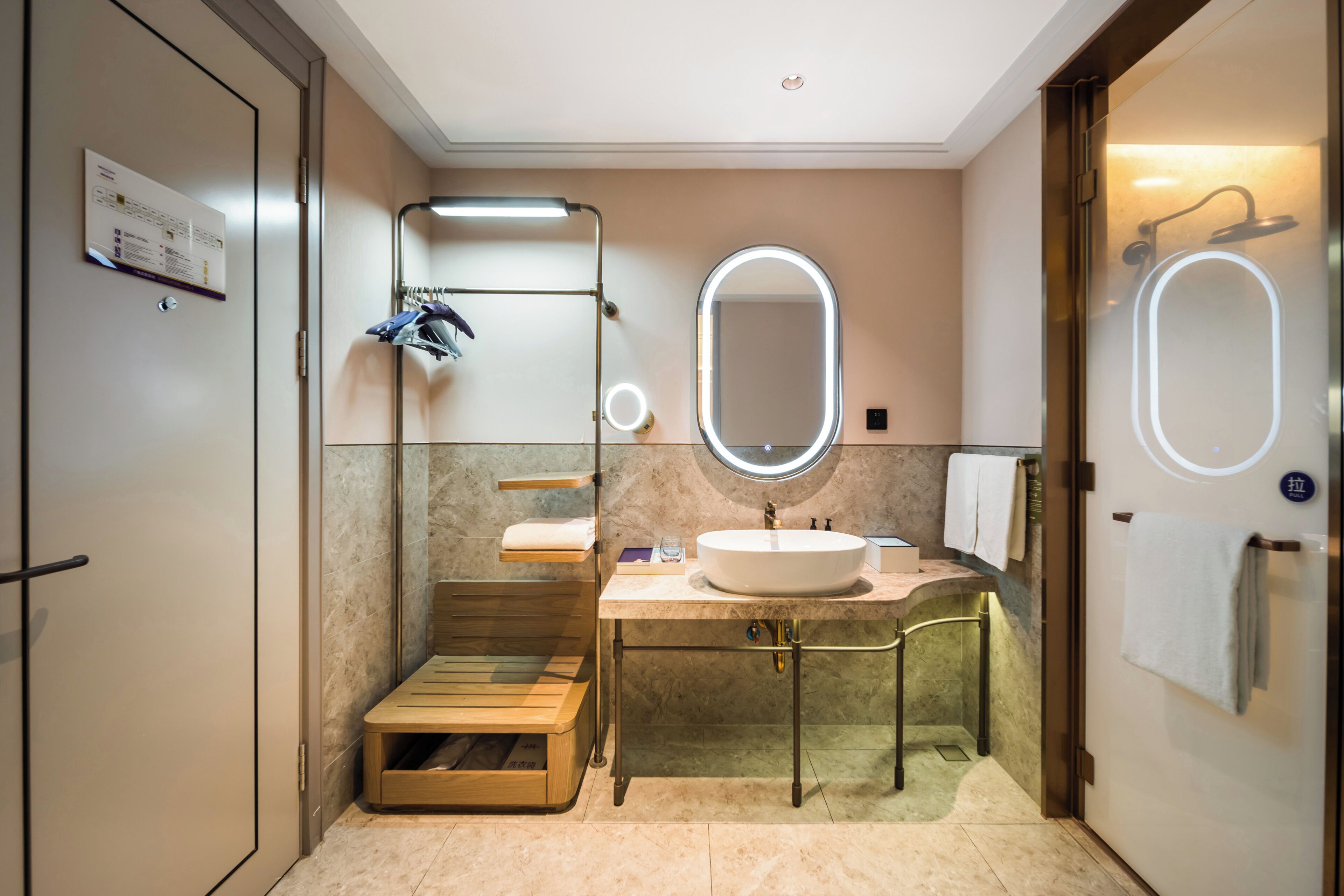 Un baño moderno con un banco de madera, un lavabo con espejo y zona de ducha.