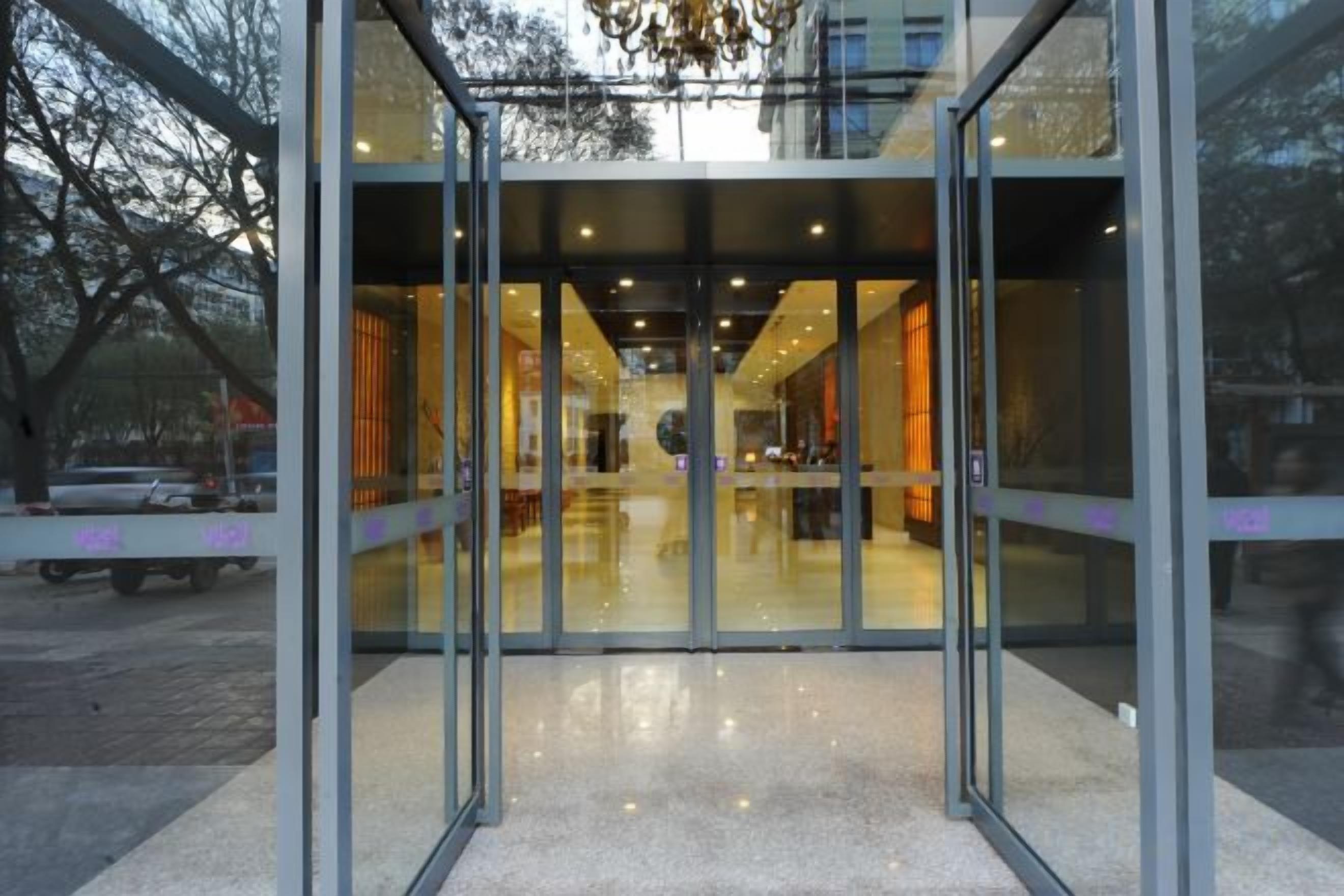 A modern building entrance with glass doors and a reflective floor.