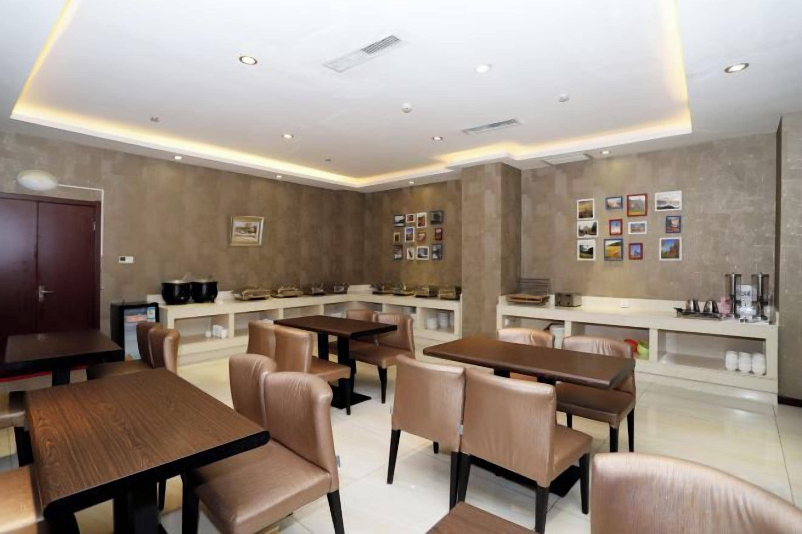 Un restaurant moderne doté de plusieurs tables et chaises, d’un espace cuisine et d’un bar.