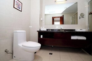 A modern bathroom with a white toilet, dark wooden vanity, and a large mirror. - Tangyue Hotel (Yan'an)