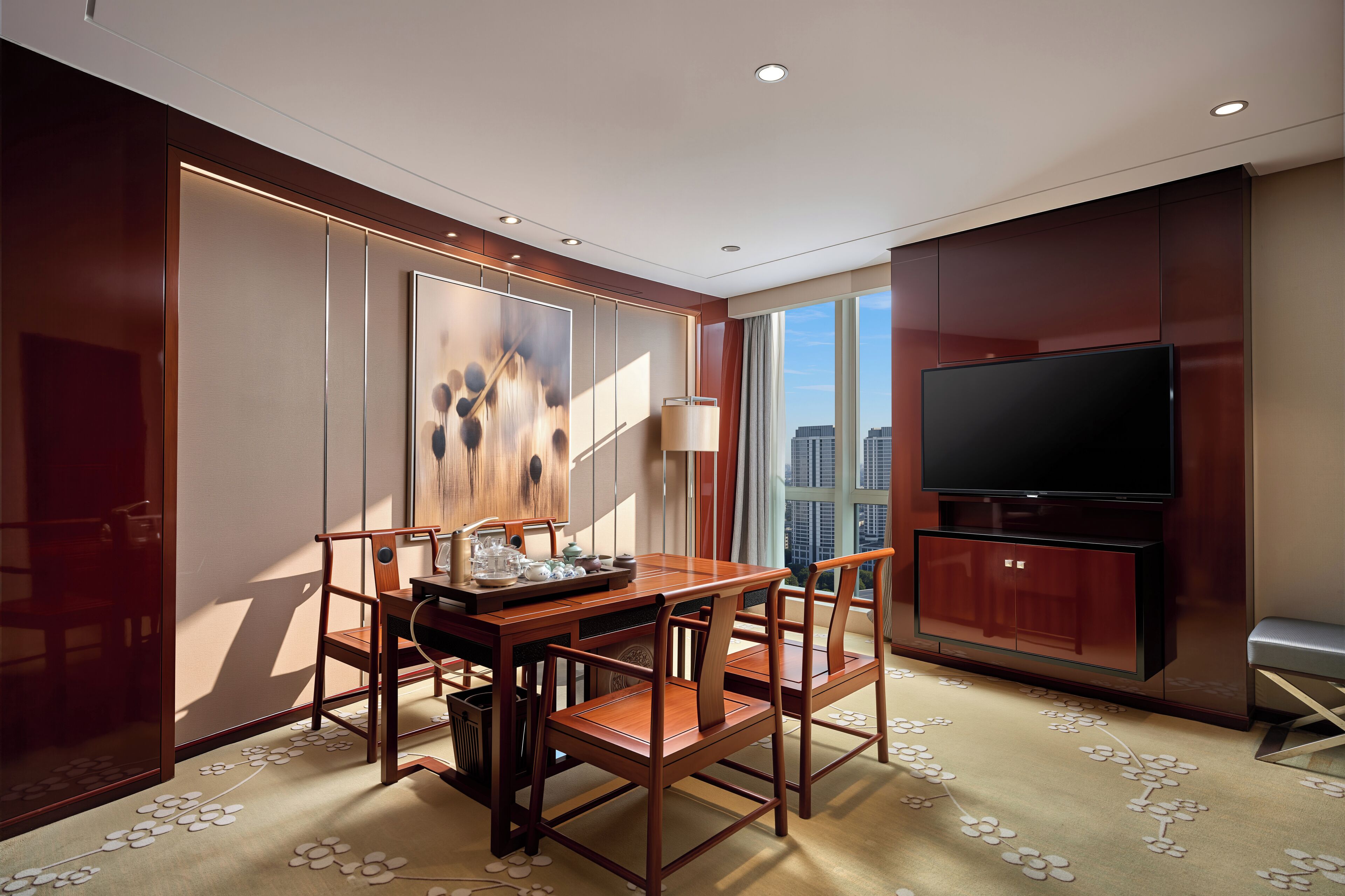 Quarto de hotel moderno com área de refeições, televisão de tela plana e vista para a cidade.