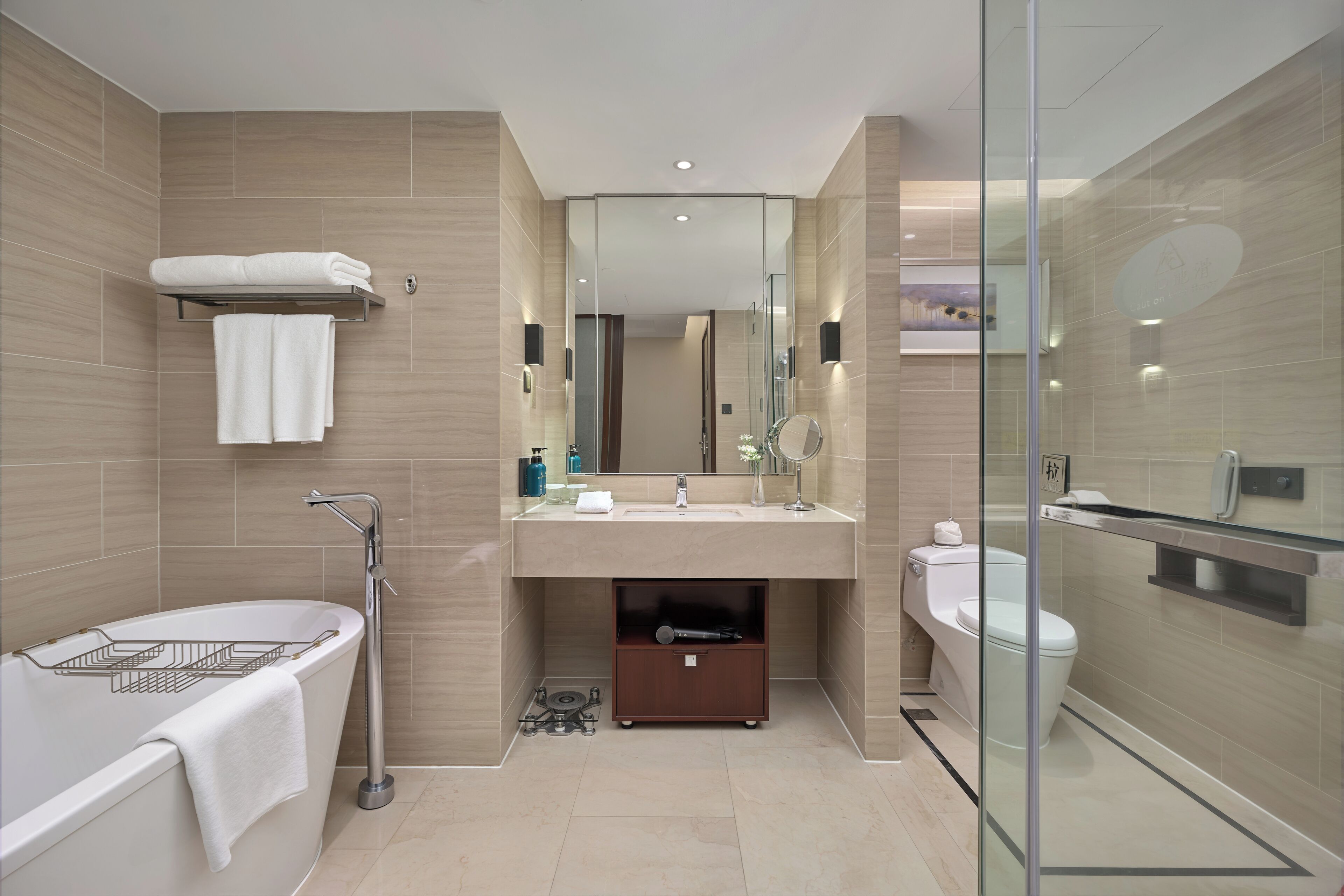 A modern bathroom with a bathtub, a toilet, and a glass-enclosed shower area.