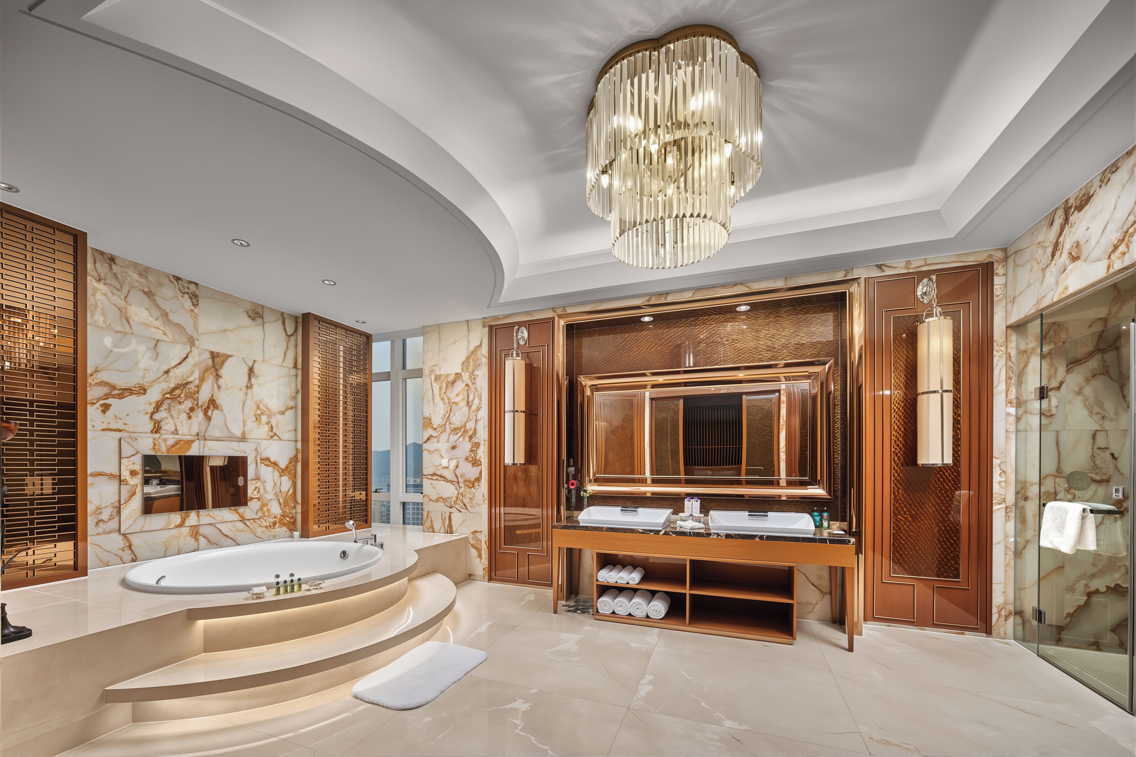 A luxurious bathroom with a large bathtub, a vanity with a mirror, and a shower area.
