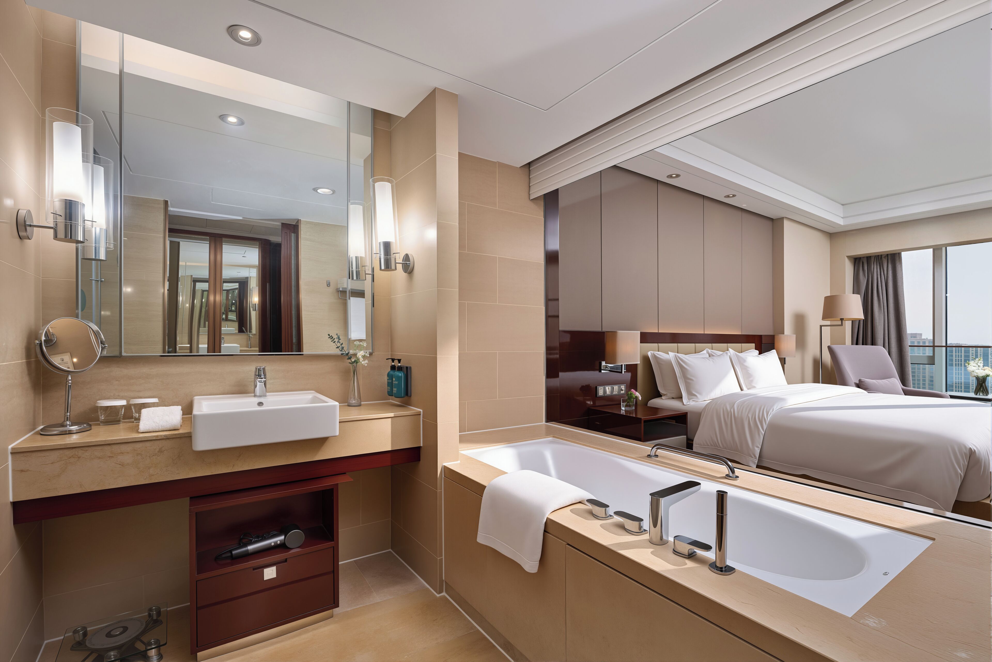 A modern hotel bathroom with a large mirror, two sinks, a bathtub, and a large bed with a city view.