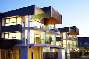 A multi-story hotel with balconies and large windows.