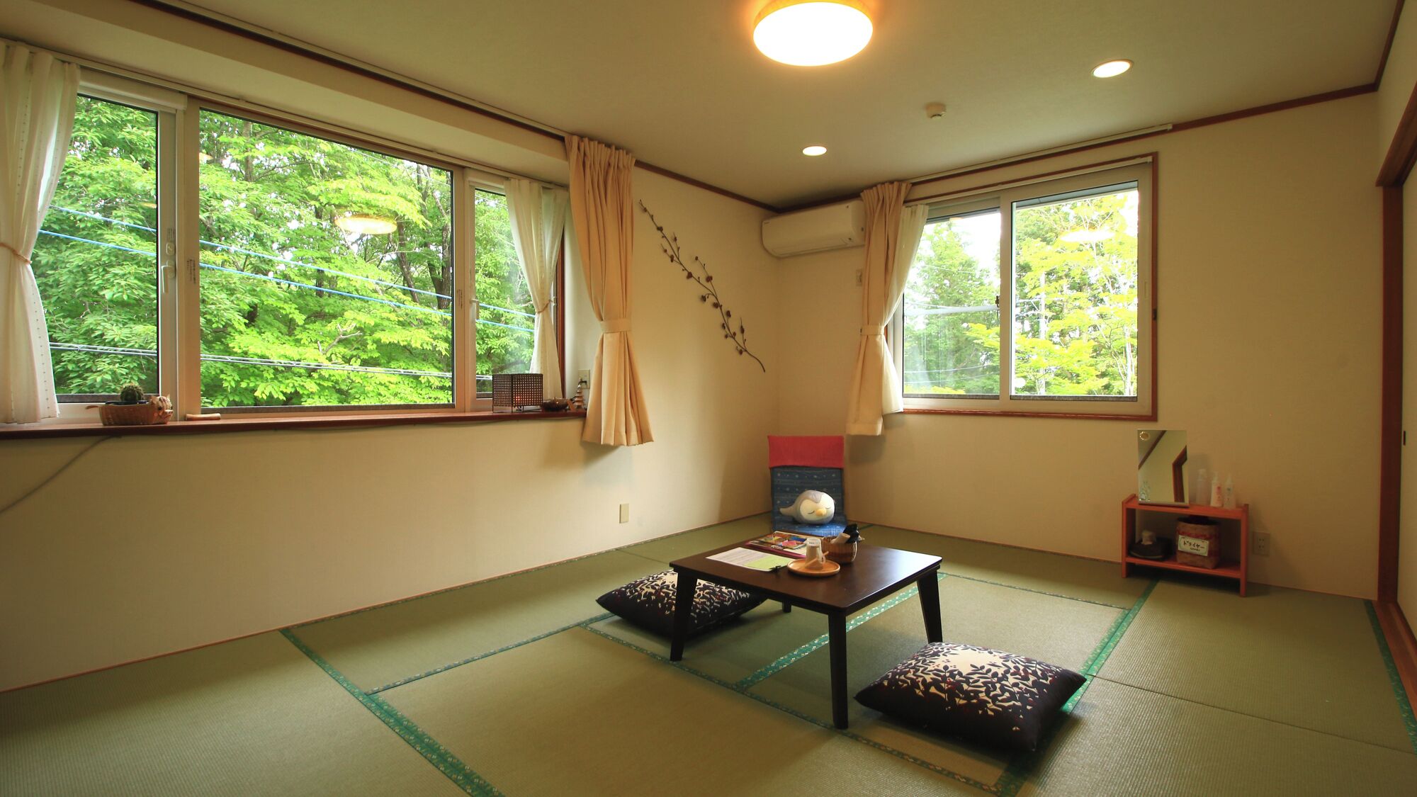 A traditional Japanese room with tatami flooring, a low table, and a futon bed.