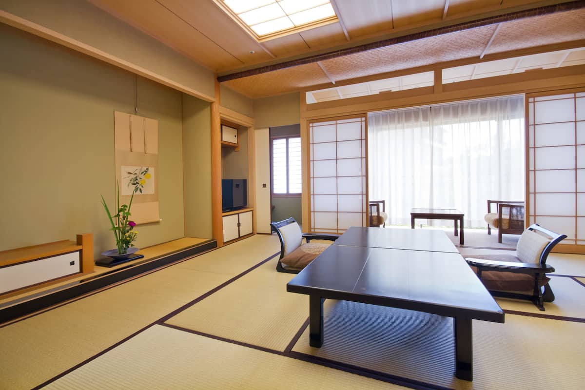 Een traditionele Japanse kamer met tatami vloerbedekking, een lage tafel en zitplaatsen.