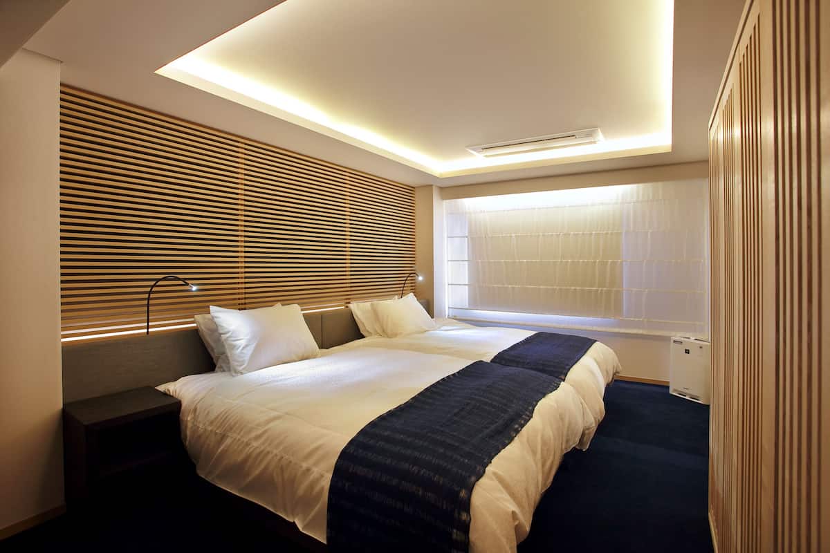 Een moderne hotelkamer met een groot bed, een vastgezet hoofdbord en een dakraam.