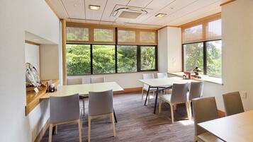 A conference room with large windows, wooden ceiling, and modern furniture.