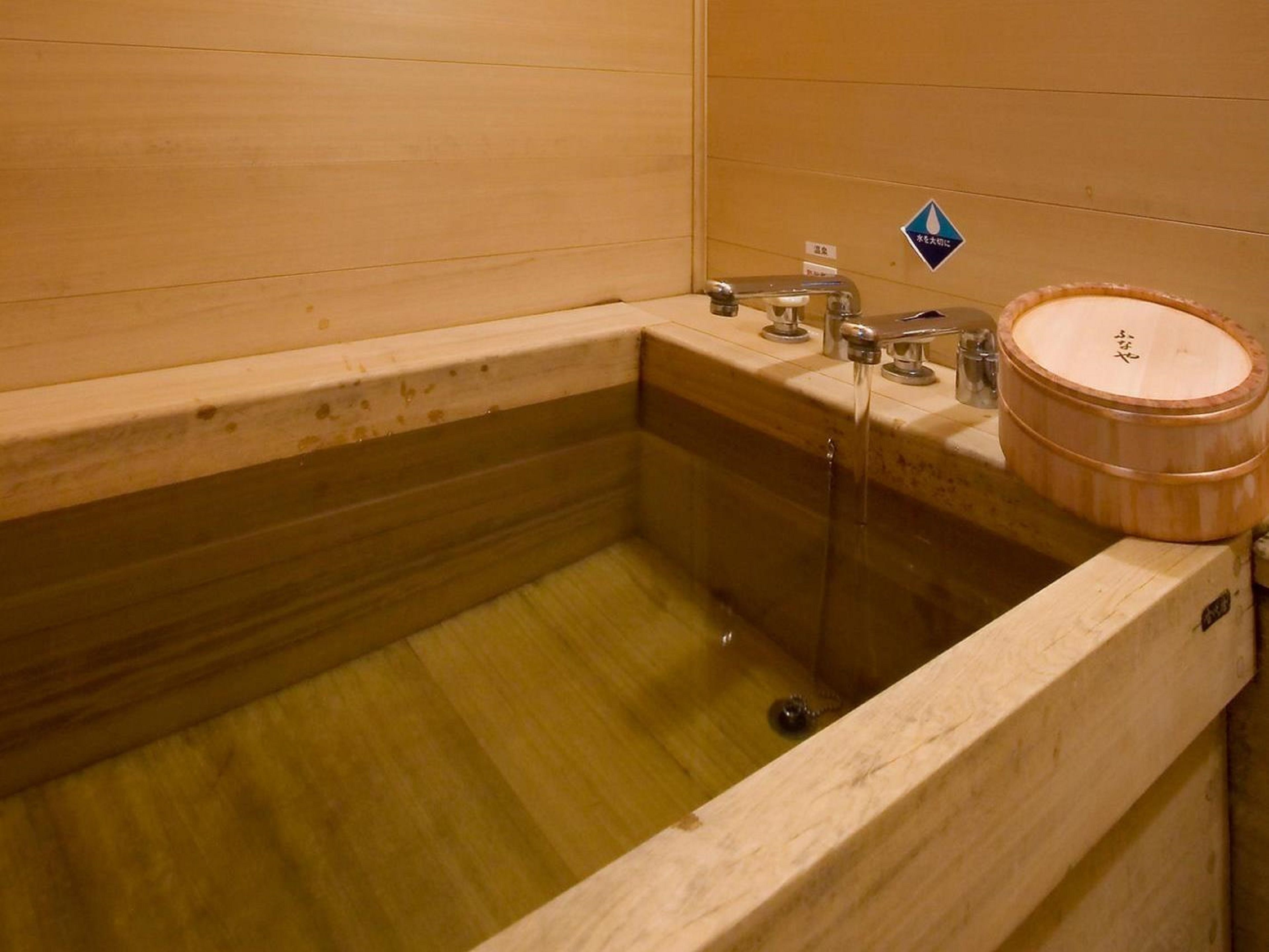 Una bañera de madera con una tina y un lavamanos de madera.