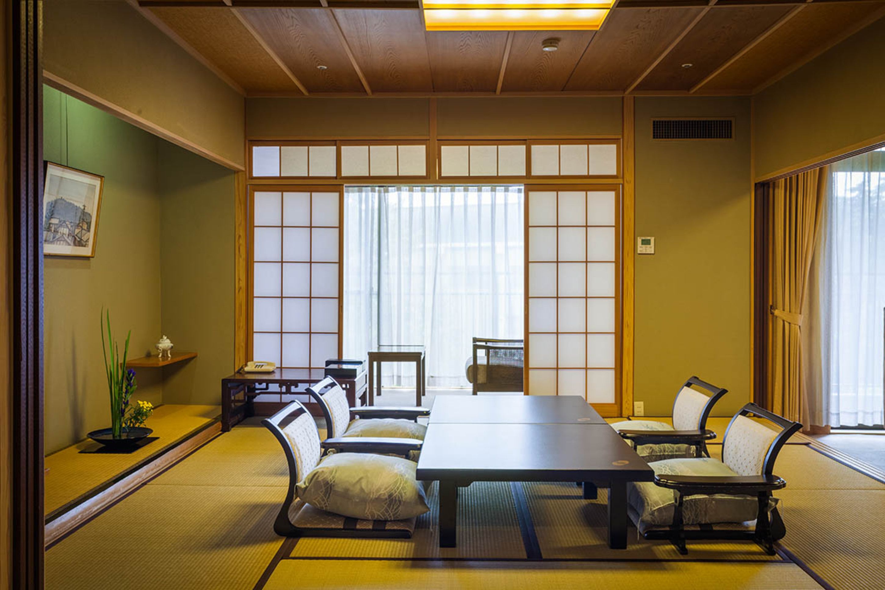 Une pièce de style japonais traditionnel, avec un sol recouvert de tatamis, une table basse et des sièges.