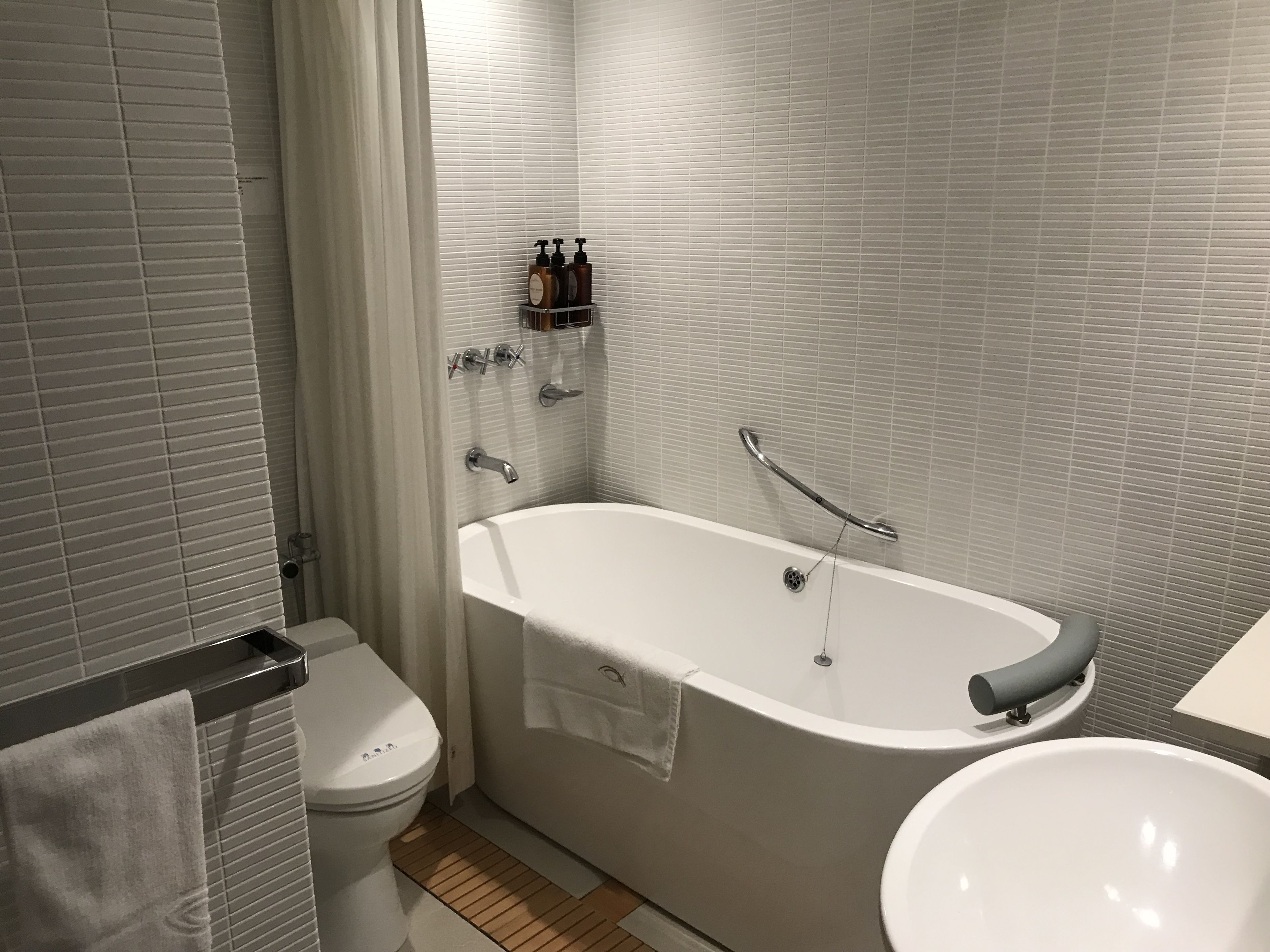 A modern bathroom with a freestanding bathtub, a toilet, and a sink.