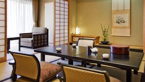 A traditional Japanese-style room with tatami flooring, a low table with tea set, and a sliding shoji screen door. - Dogo Onsen Funaya (Matsuyama)