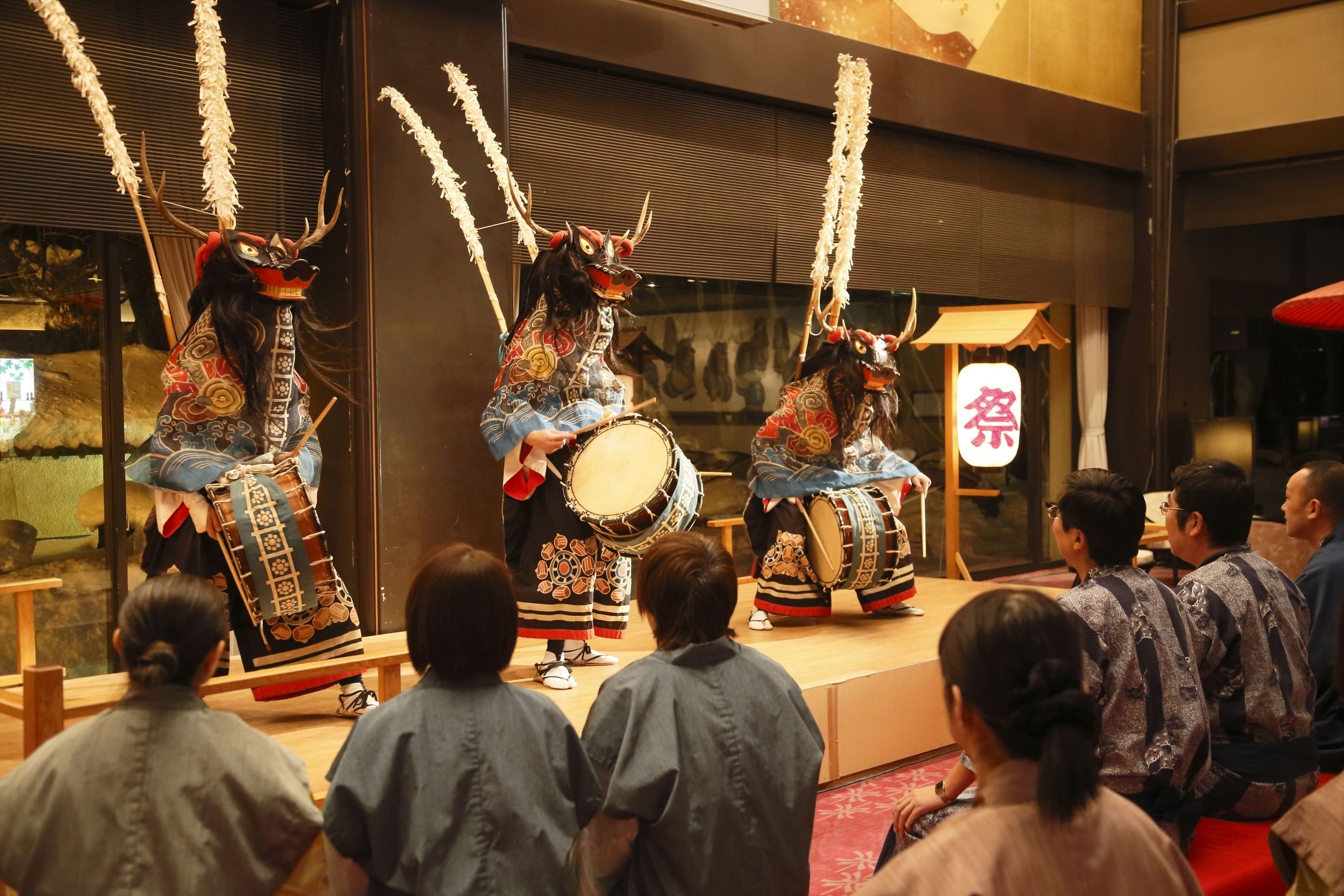 A traditional performance with performers in elaborate costumes and masks.