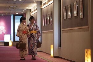 A hallway with framed pictures on the wall and a red carpet.