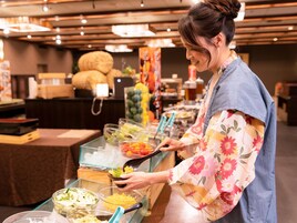 Una barra de buffet con diferentes opciones de comida y una persona sirviéndose.
