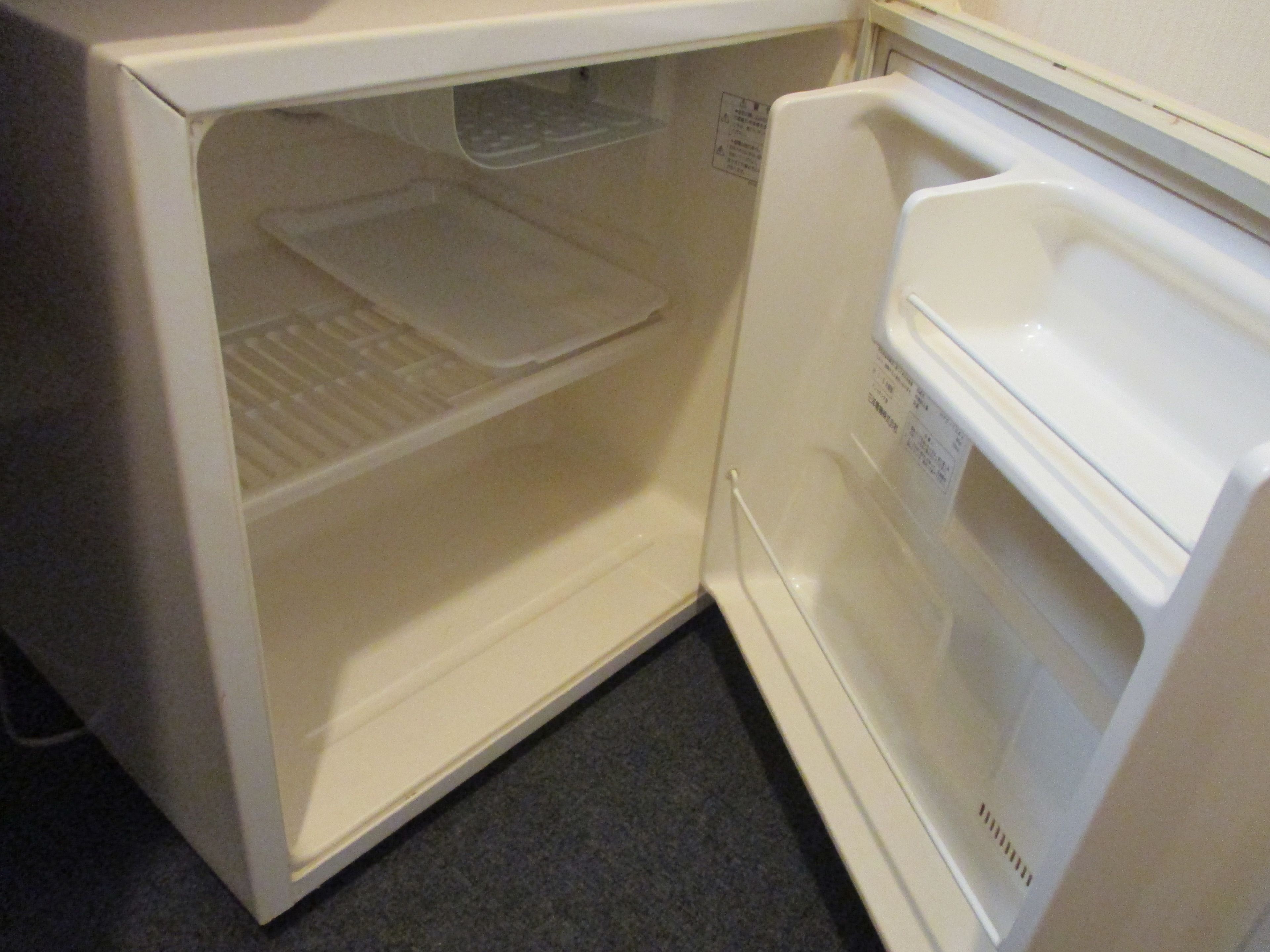 Un refrigerador abierto con un estante y un compartimento congelador.