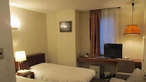 A hotel room with two beds, a desk with a television, a lamp, and a couch. - Fukui Palace INN (Fukui)