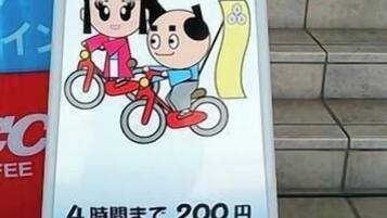 Una señal con una ilustración de bicicleta y texto en japonés, indicando un cargo de 200 yenes por un alquiler de 4 horas.