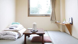 A small, tidy room with a bed, a table with a kettle, a window with curtains, and a shelf with items. - Hotel Fukui Castle (Fukui)