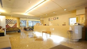 A hotel lobby with a reception desk, seating area, and a view of the outdoors. - Hotel Fukui Castle (Fukui)