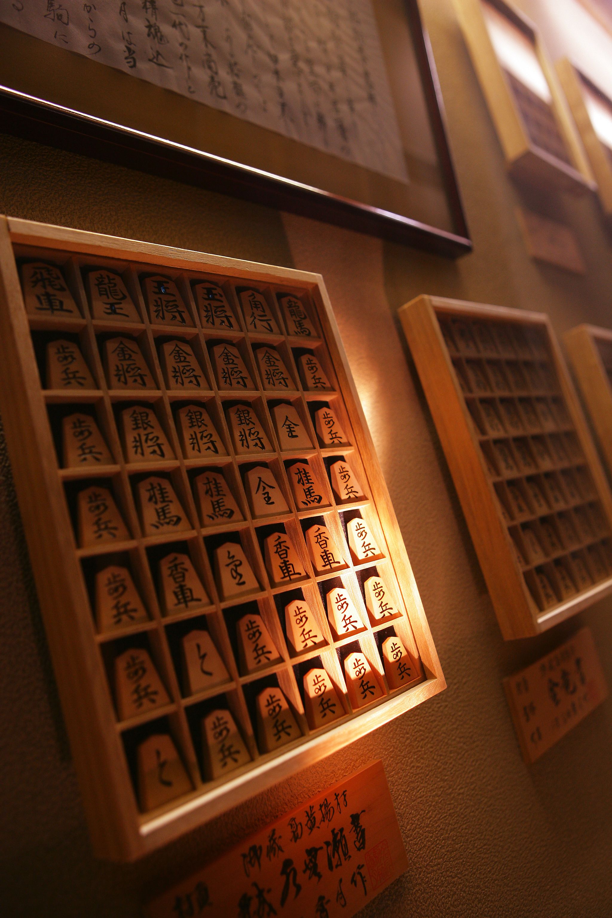 A display of calligraphy with wooden frames and illuminated signs.