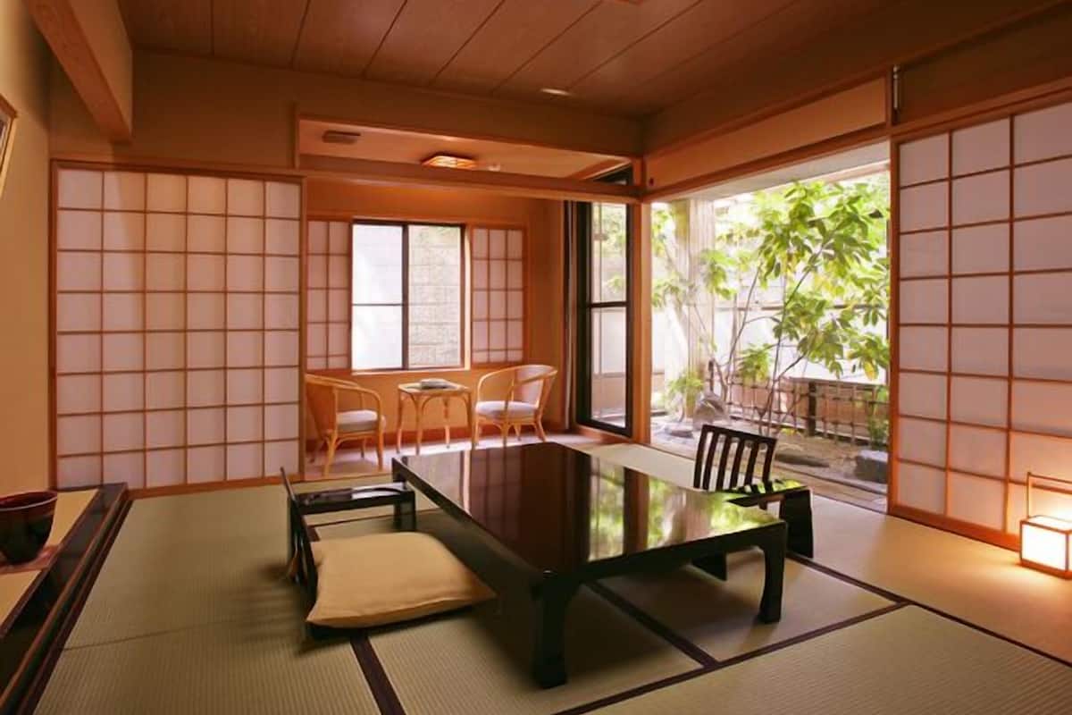A traditional Japanese room with tatami flooring, a low table, and sliding doors.