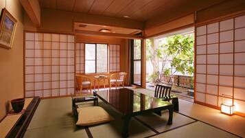 A traditional Japanese room with tatami flooring, a low table, and sliding doors.