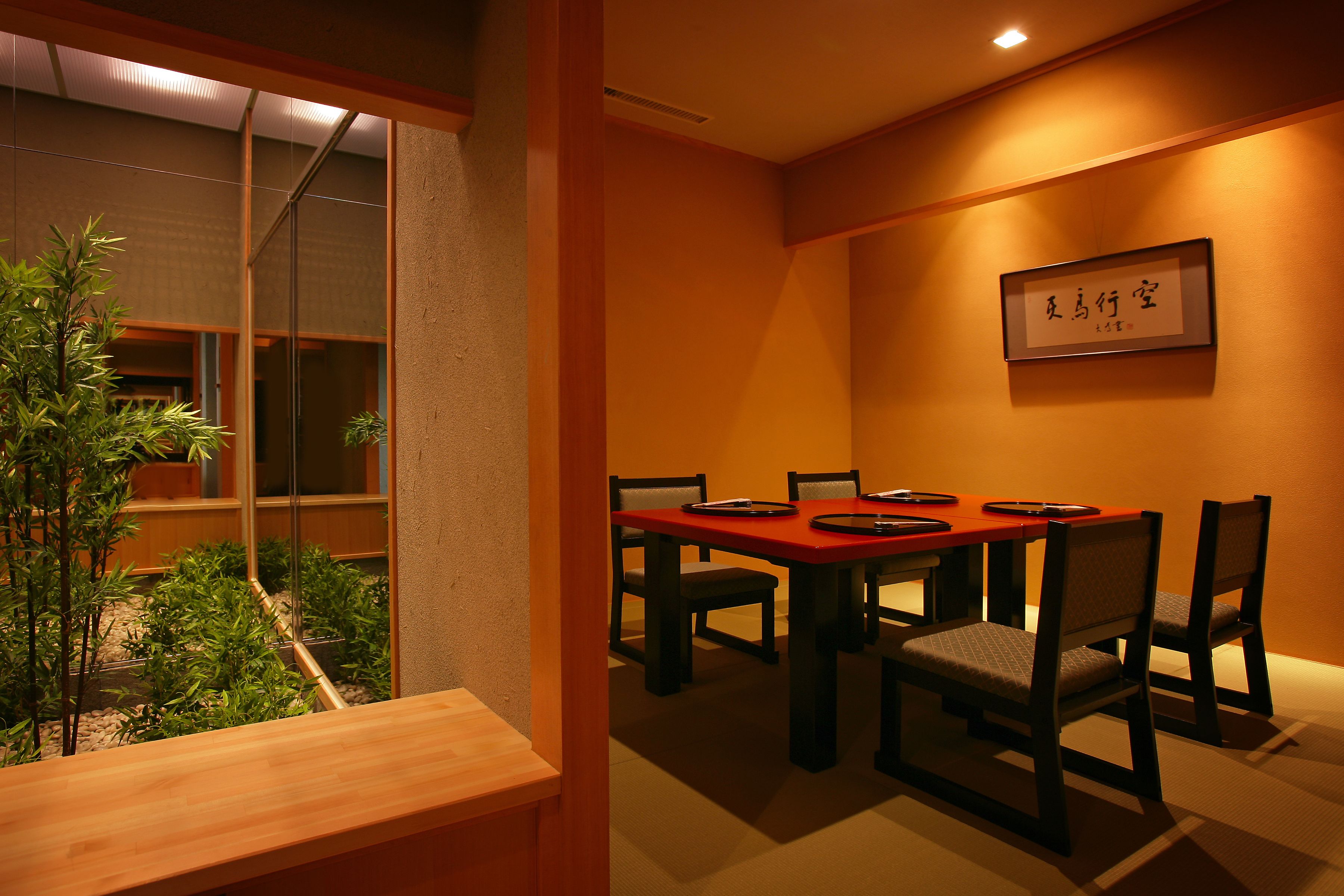 Una sala menjador tradicional japonesa amb una taula baixa i sis cadirees.