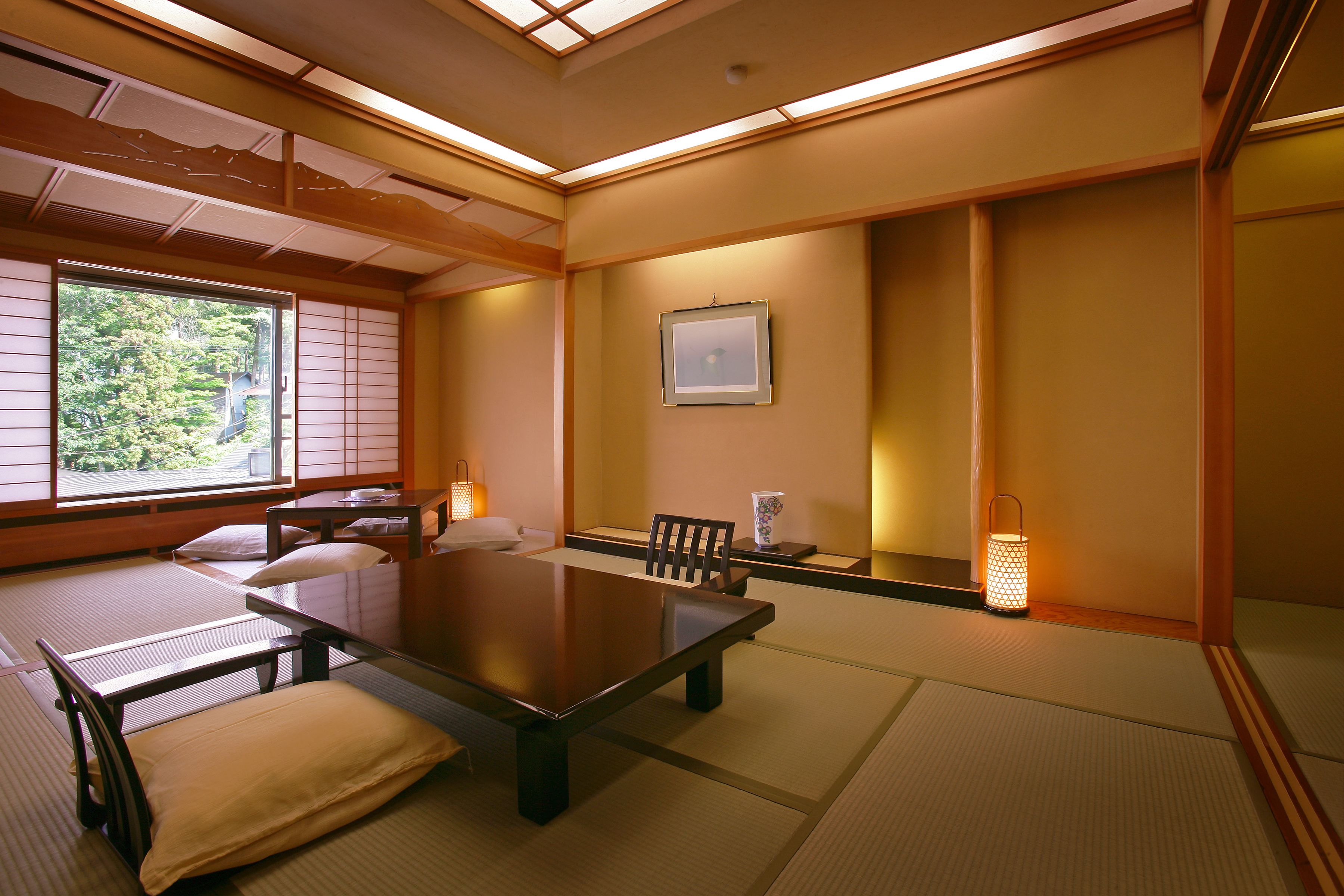 A traditional Japanese room with tatami flooring, a low table, and cushions.