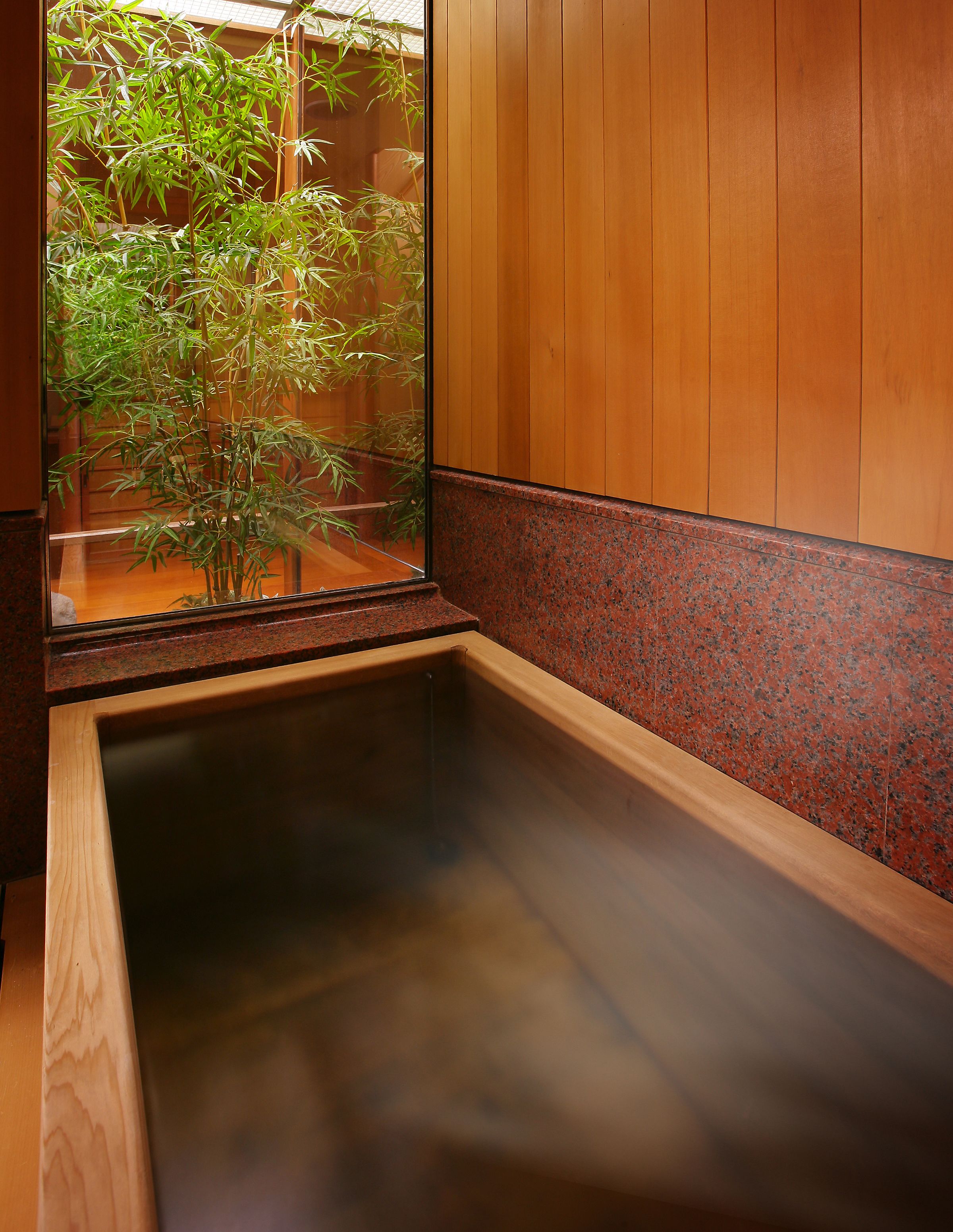 A traditional Japanese soaking tub with a wooden frame and a glass window.