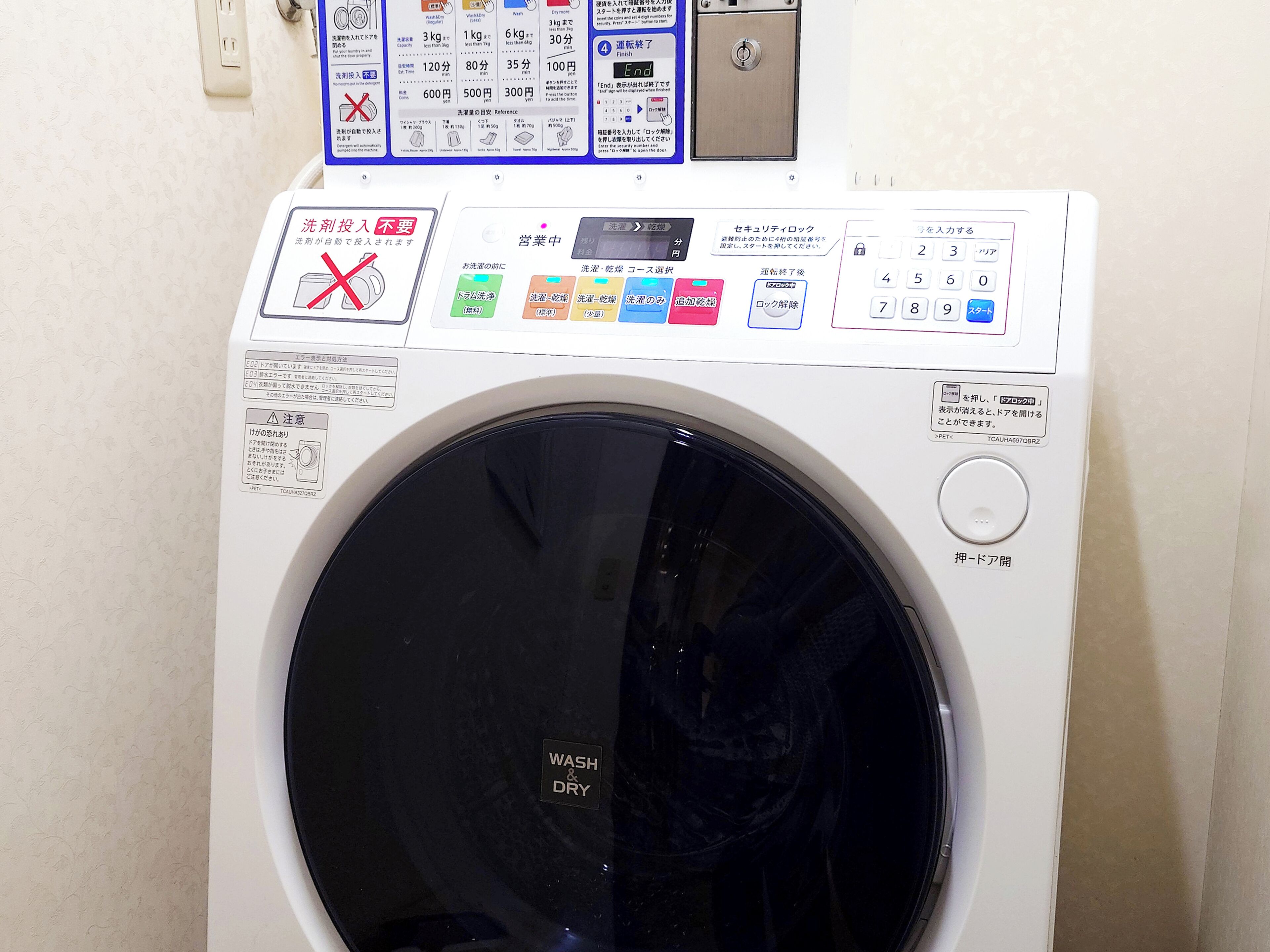 A front-loading washing machine with a control panel displaying various settings and instructions.