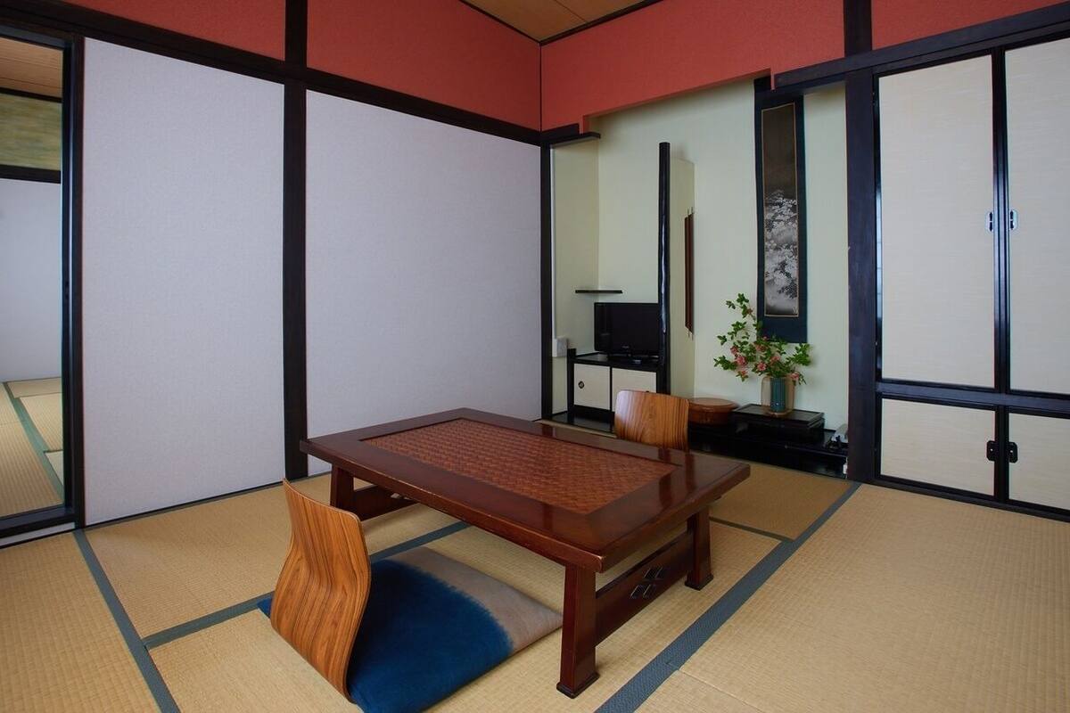 Perinteinen japanilainen huone, jossa on tatamimatto, puinen pöytä ja liukuseinät.