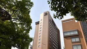 Un edificio alto y moderno con un logotipo destacado en la parte superior.