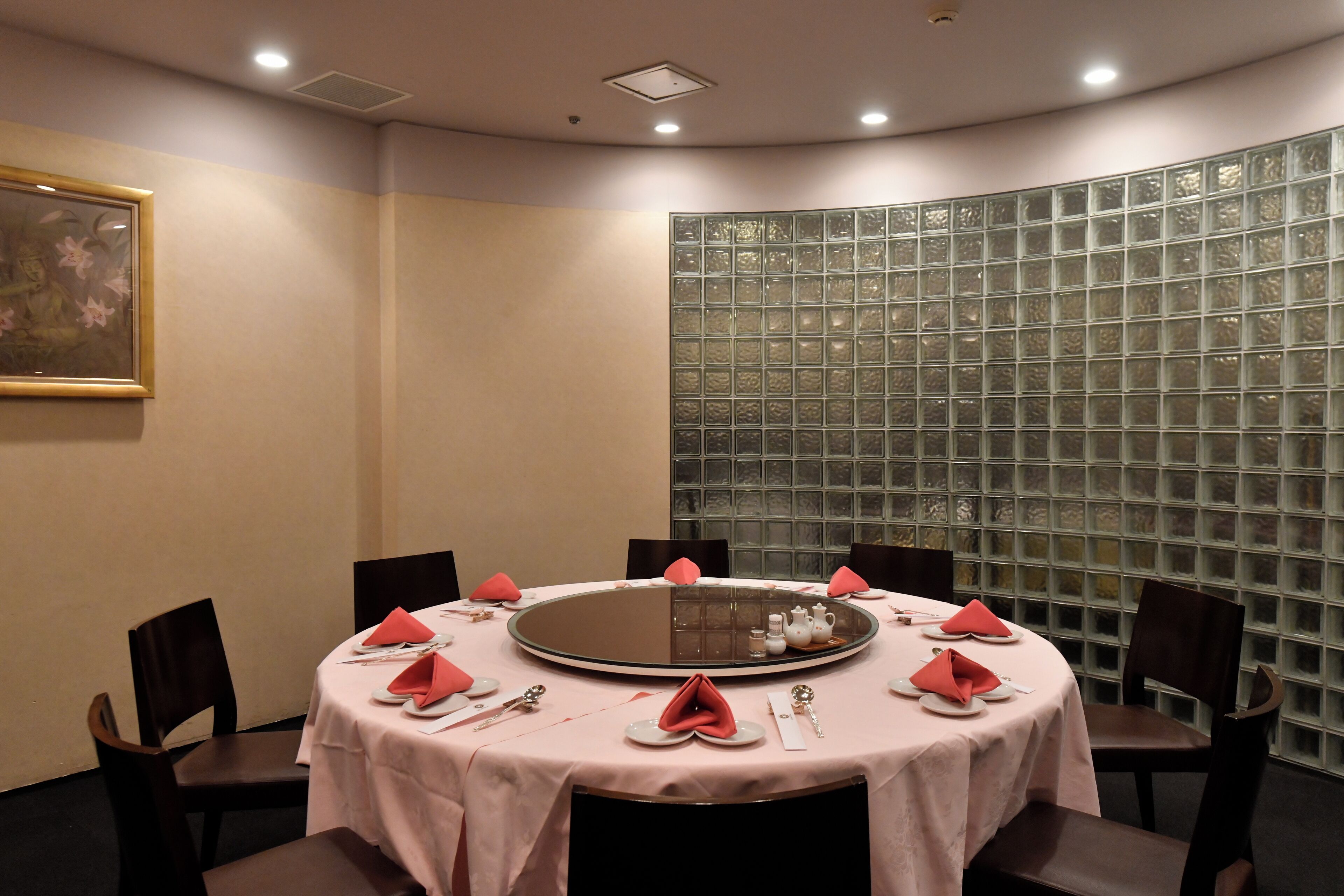 A conference room with a round table, chairs, and a decorative glass partition.