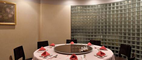 A conference room with a round table, chairs, and a decorative glass partition.