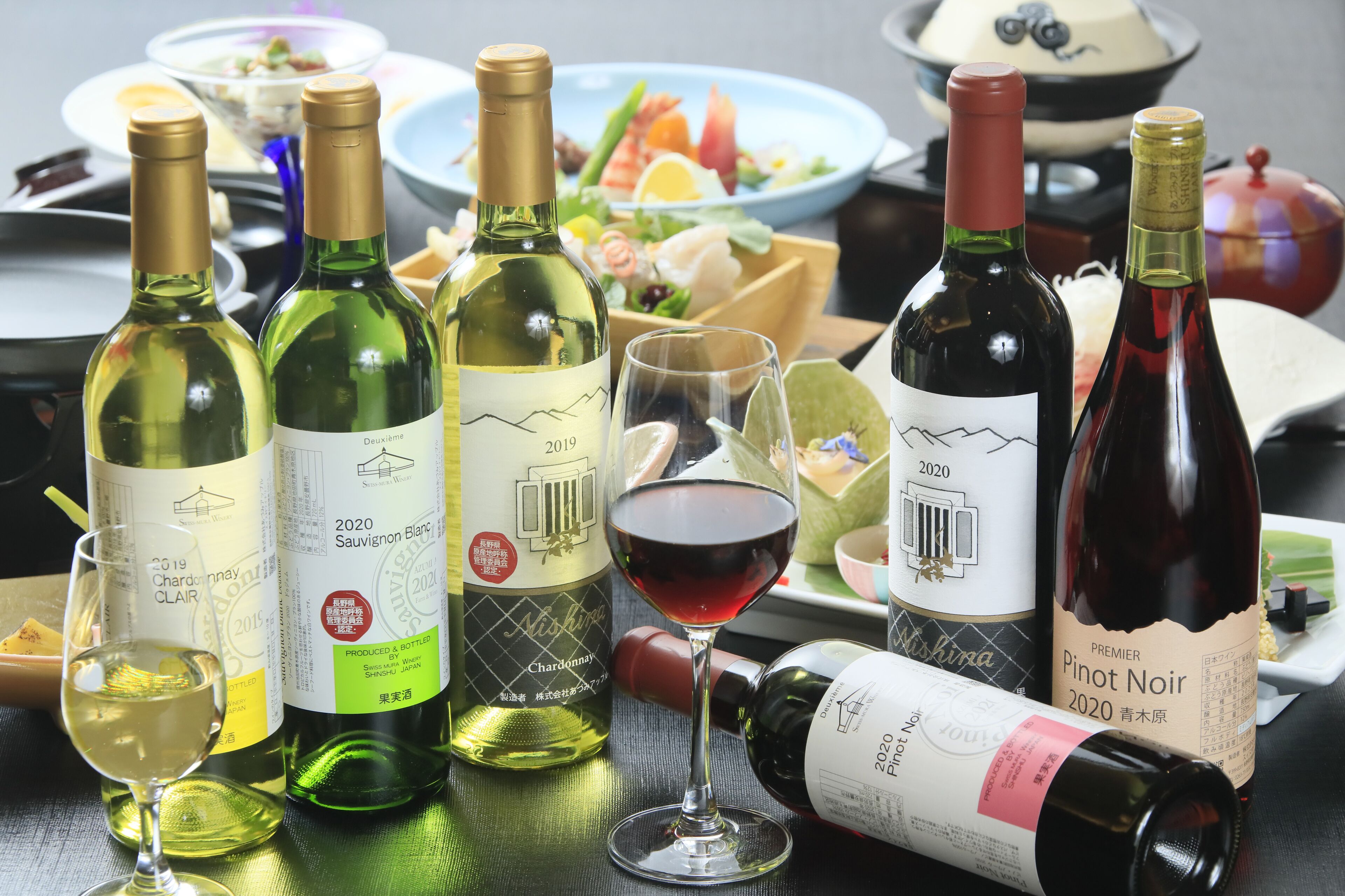 A table with various wine bottles and glasses, indicating a wine tasting event.