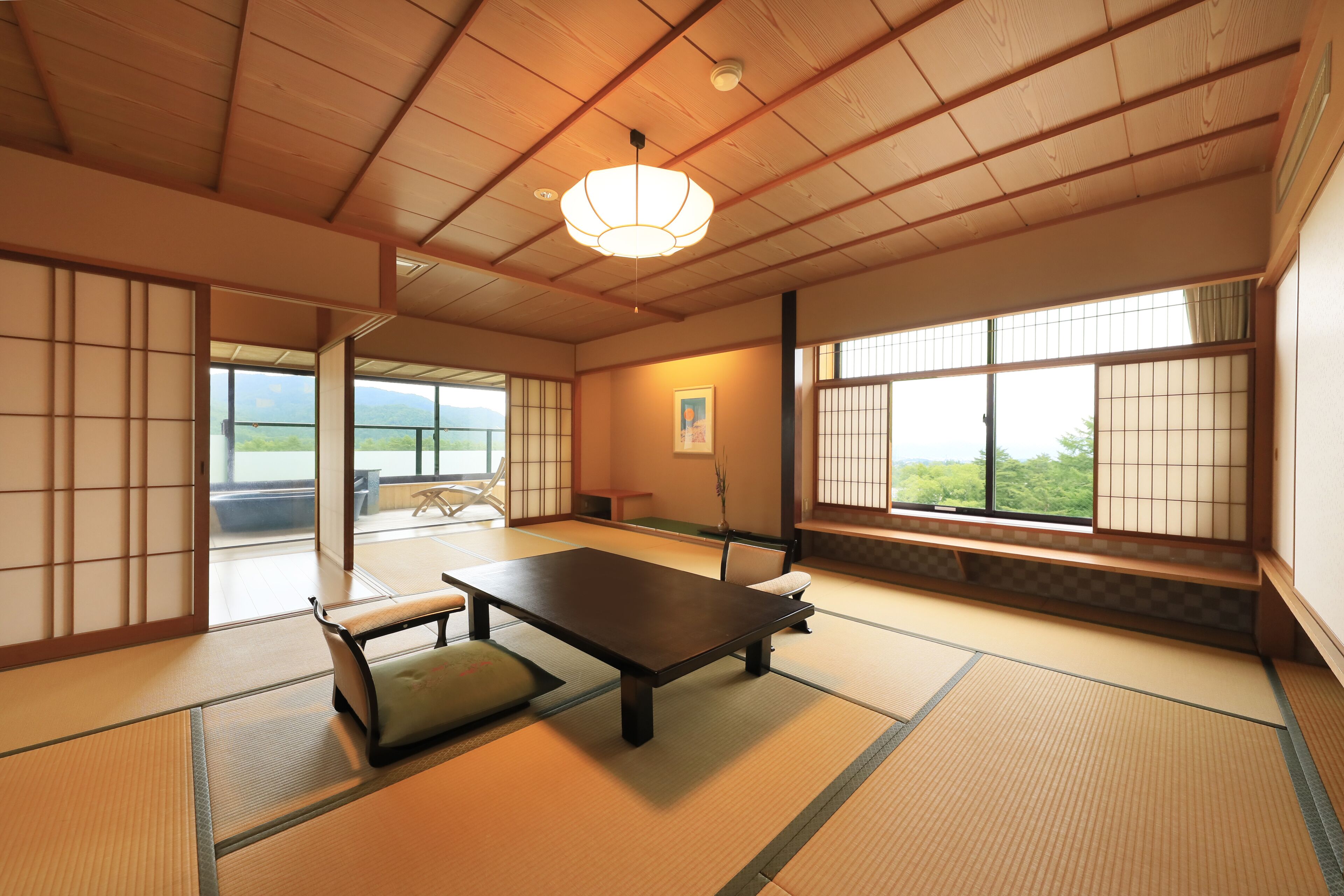 Una habitación japonesa tradicional con suelo de tatami, una mesa baja y puertas correderas.