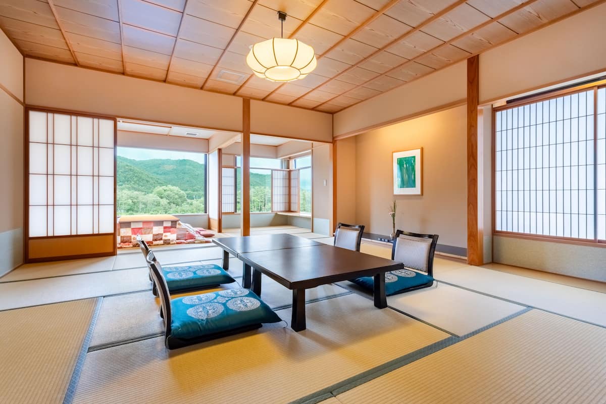 A traditional Japanese room with tatami flooring, a low table, and cushions.